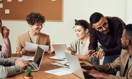 A diverse group of professionals engaged in a collaborative office meeting, sharing ideas and discussing projects.