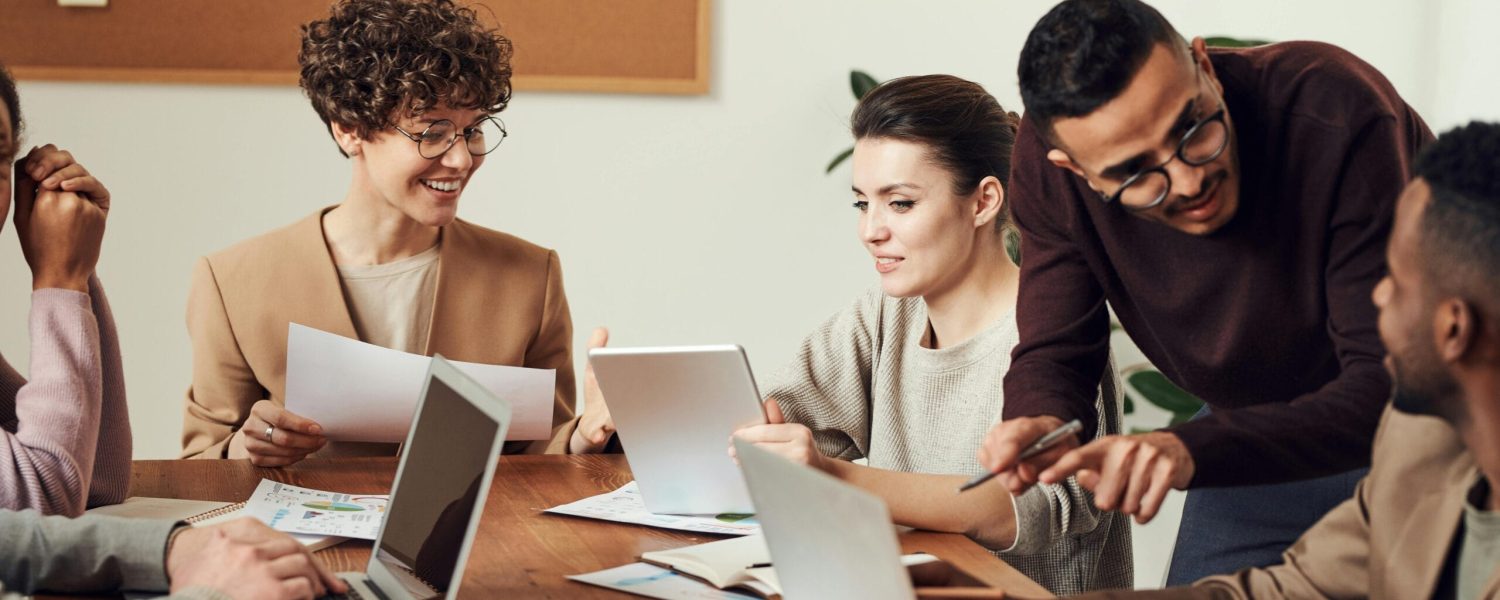 A diverse group of professionals engaged in a collaborative office meeting, sharing ideas and discussing projects.