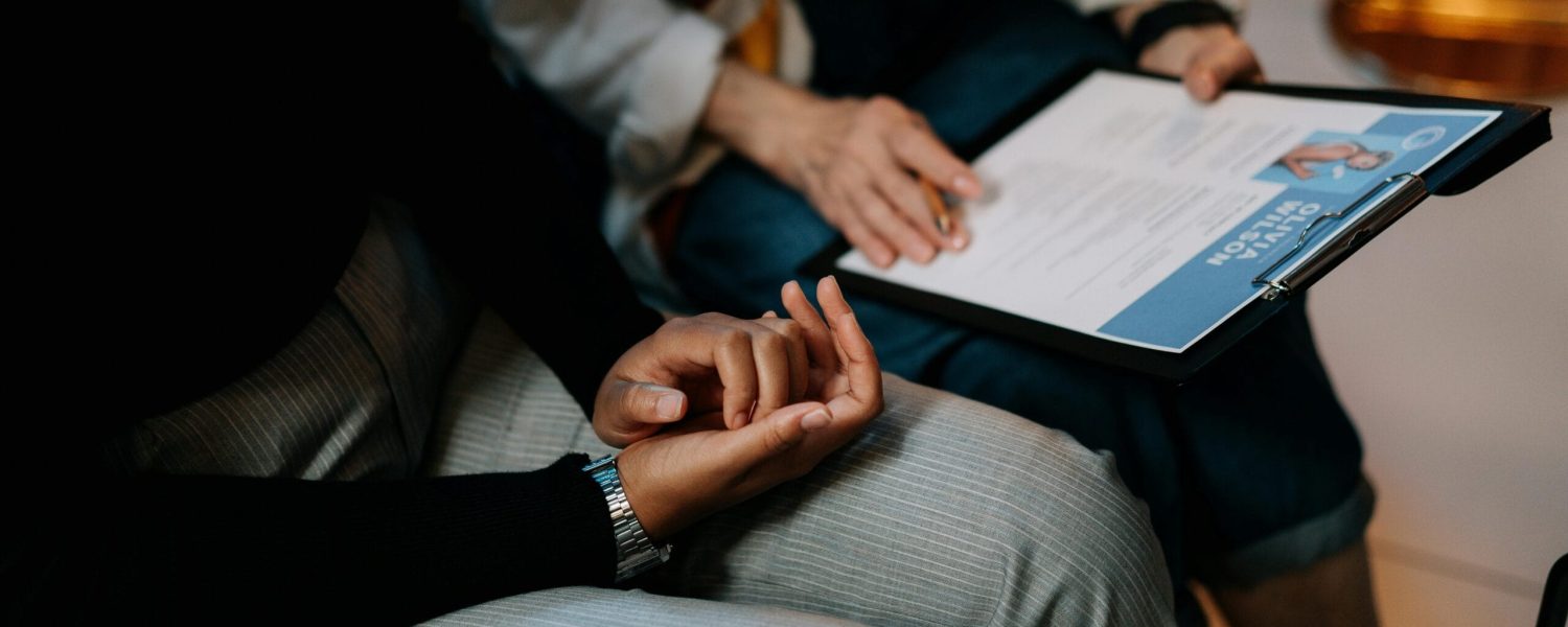 Two professionals reviewing a resume in an office setting, focused on teamwork.